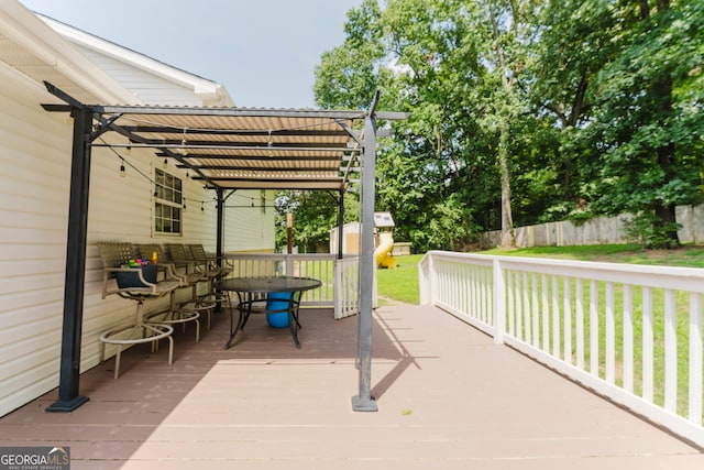 deck featuring a pergola and a lawn