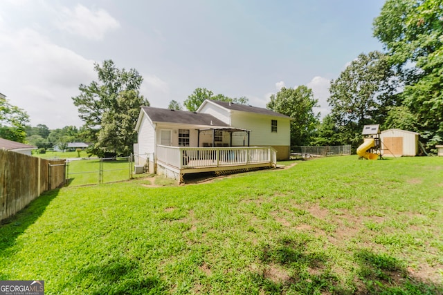 rear view of house with a wooden deck and a lawn