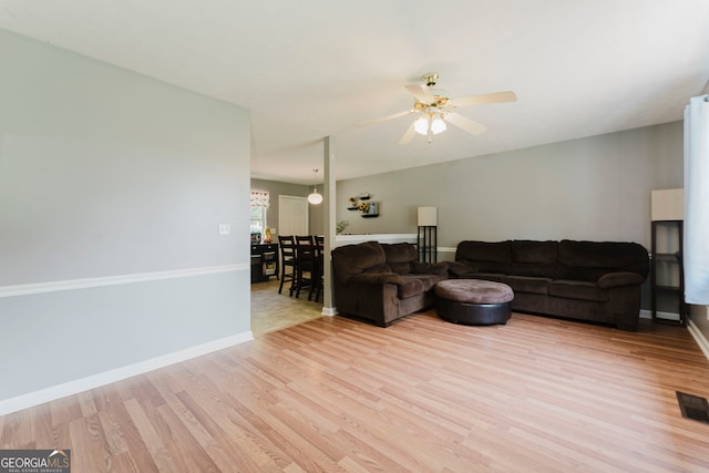 living room with ceiling fan and light wood-type flooring