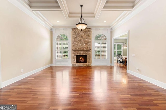 unfurnished living room with coffered ceiling, a stone fireplace, wood-type flooring, and ornamental molding