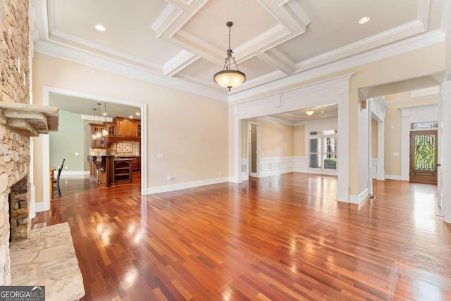 unfurnished living room with coffered ceiling, crown molding, dark hardwood / wood-style flooring, beamed ceiling, and a fireplace