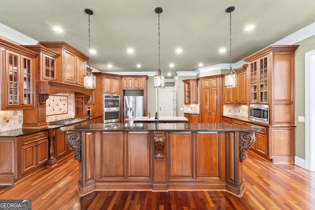 kitchen with a large island, hanging light fixtures, and appliances with stainless steel finishes