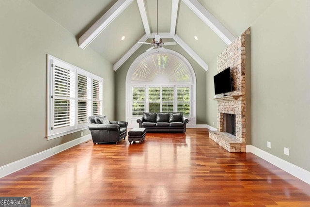 living room featuring wood-type flooring, high vaulted ceiling, ceiling fan, and a fireplace