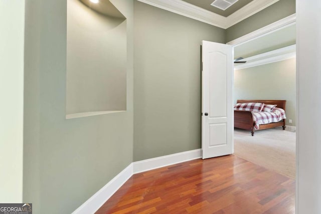 hallway featuring ornamental molding and hardwood / wood-style floors