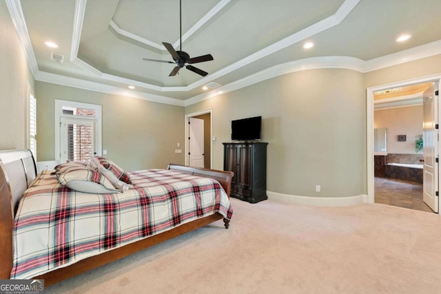 carpeted bedroom with crown molding, ceiling fan, ensuite bath, and a tray ceiling