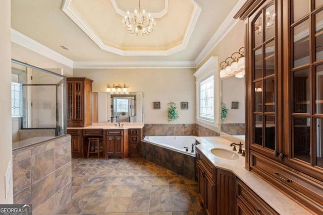 bathroom with vanity, a tray ceiling, ornamental molding, independent shower and bath, and a chandelier