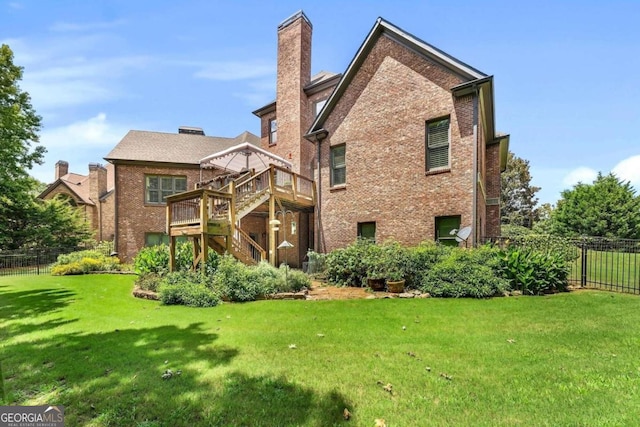 back of house with a wooden deck and a lawn