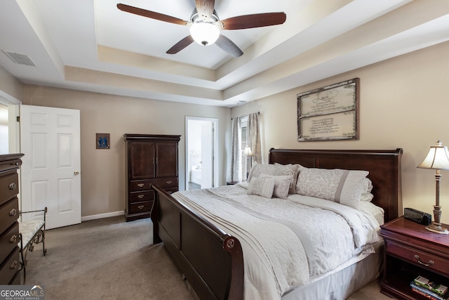 bedroom featuring ensuite bathroom, carpet floors, ceiling fan, and a tray ceiling