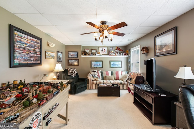 playroom with ceiling fan, carpet flooring, and a drop ceiling