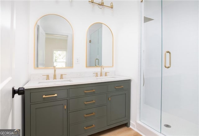 bathroom with a shower with door, hardwood / wood-style flooring, and double vanity