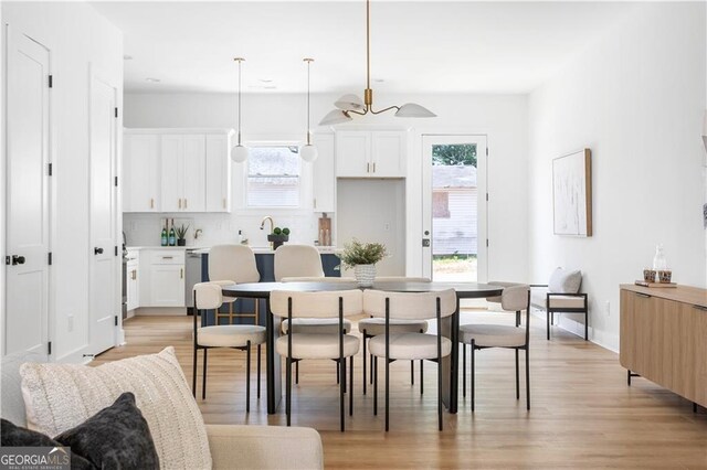 dining space with light wood-type flooring and a chandelier