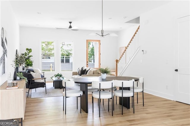 dining area with light wood-type flooring and ceiling fan