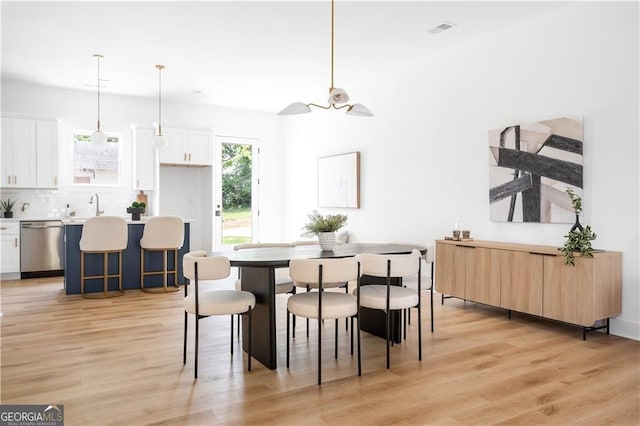 dining space featuring light hardwood / wood-style flooring, sink, and ceiling fan