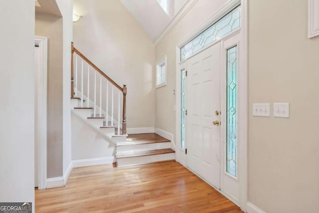 foyer featuring light hardwood / wood-style flooring, lofted ceiling, and plenty of natural light