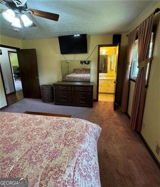 carpeted bedroom with a textured ceiling, ceiling fan, and connected bathroom