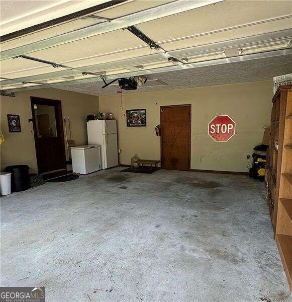 garage with white refrigerator and a garage door opener