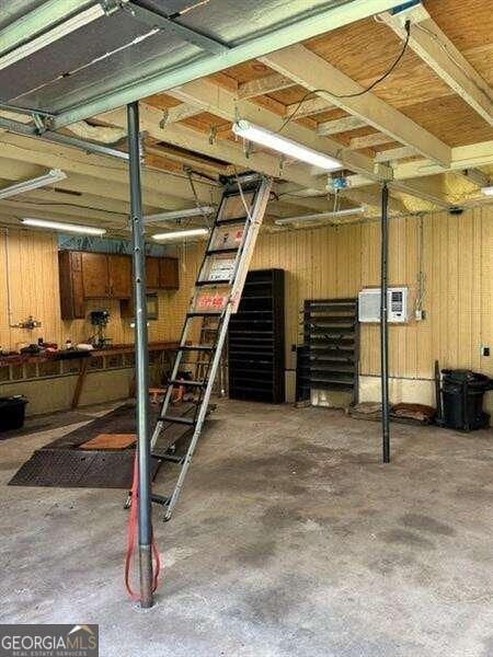 basement with wood walls and a wall mounted air conditioner