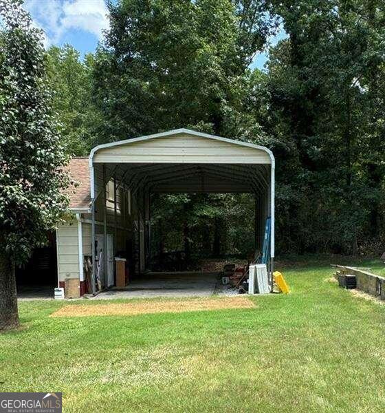 view of car parking with a carport and a yard