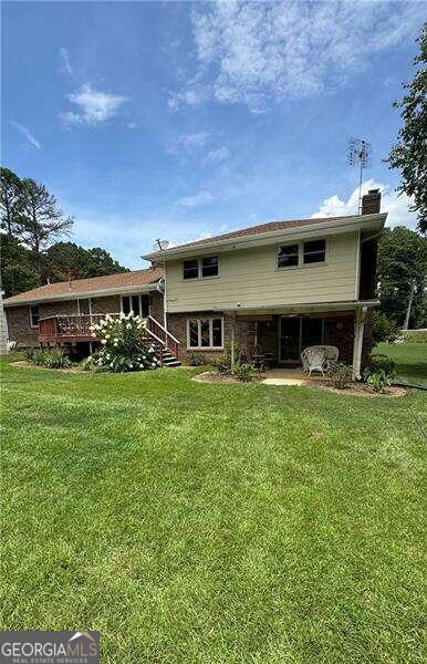 rear view of property featuring a yard