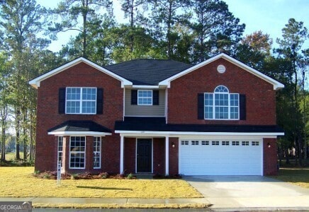 view of front of property with a garage and a front lawn