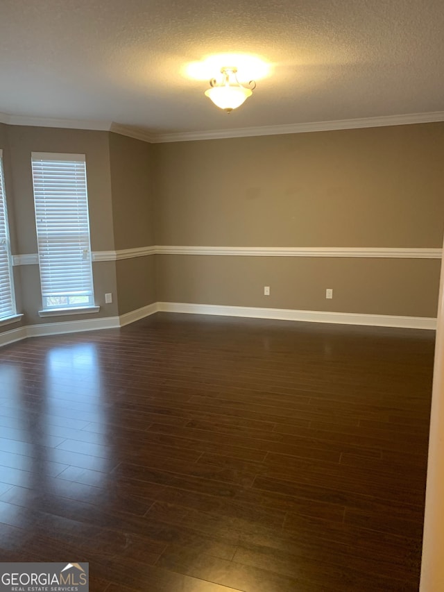 unfurnished room with crown molding, dark hardwood / wood-style flooring, and a textured ceiling