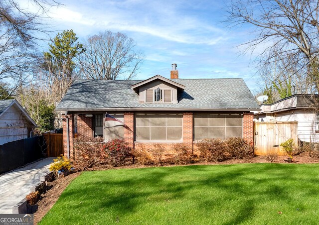 bungalow featuring a front lawn and a sunroom