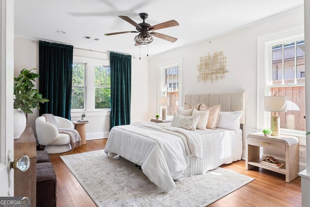 bedroom featuring ceiling fan, hardwood / wood-style flooring, and crown molding