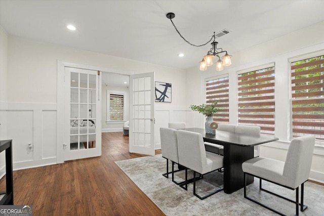 dining room with an inviting chandelier, hardwood / wood-style flooring, and french doors