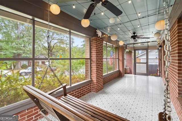 unfurnished sunroom with ceiling fan