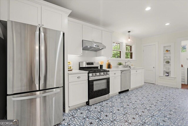 kitchen with white cabinetry, appliances with stainless steel finishes, sink, and hanging light fixtures