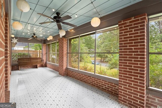 unfurnished sunroom featuring ceiling fan