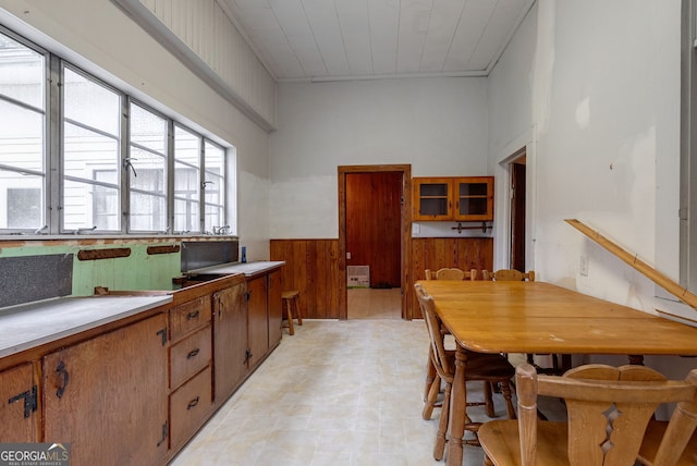 99 W Main St, Gibson, GA 30810 - kitchen featuring brown cabinetry, a wainscoted wall, wooden walls, and light countertops