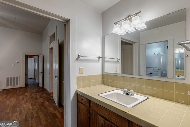 99 W Main St, Gibson, GA 30810 - bathroom with vanity, wood finished floors, and decorative backsplash