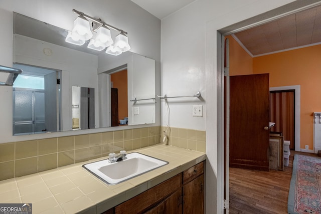 99 W Main St, Gibson, GA 30810 - bathroom featuring wood finished floors, vanity, ornamental molding, and decorative backsplash