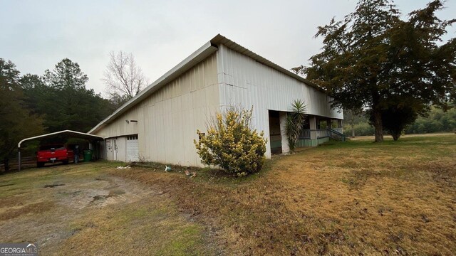 view of property exterior featuring a garage, a lawn, and a carport