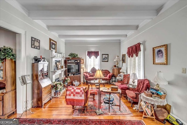 living room with light hardwood / wood-style flooring, ornamental molding, and beamed ceiling