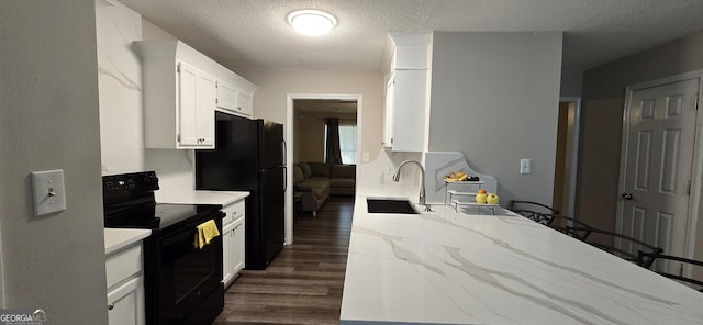 kitchen with dark wood-type flooring, sink, black appliances, a textured ceiling, and white cabinets