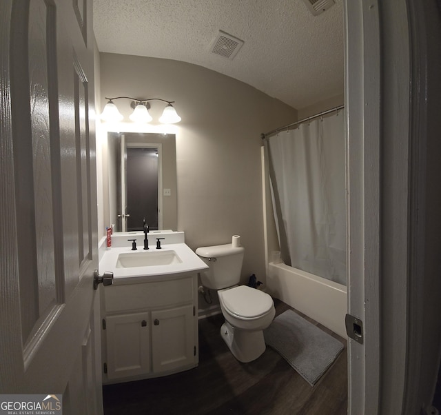 full bathroom with wood-type flooring, vanity, toilet, shower / bathtub combination with curtain, and a textured ceiling