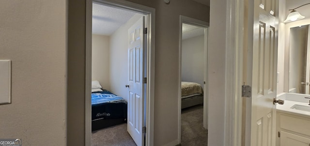 hallway featuring light colored carpet and sink