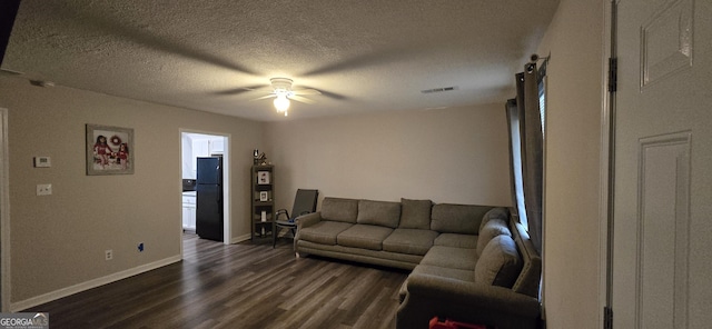 living room with dark wood-type flooring, a textured ceiling, and ceiling fan