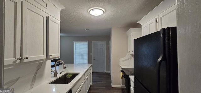 kitchen featuring sink, dark wood-type flooring, white cabinetry, light stone counters, and black appliances