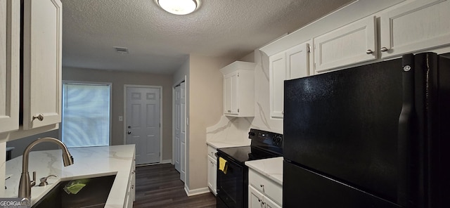 kitchen featuring sink, white cabinetry, dark hardwood / wood-style floors, black appliances, and a textured ceiling