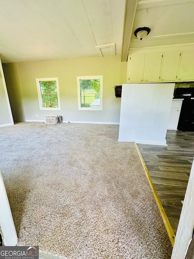 spare room with beam ceiling and hardwood / wood-style flooring