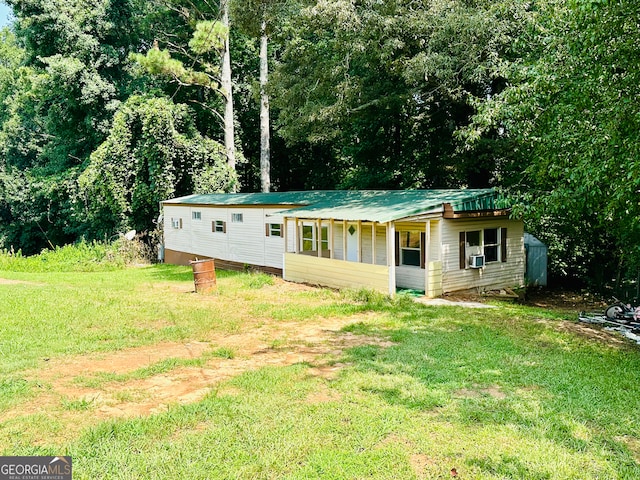 view of front of property with cooling unit and a front yard