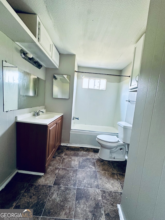 full bathroom featuring tile patterned flooring, a textured ceiling, bathtub / shower combination, toilet, and vanity