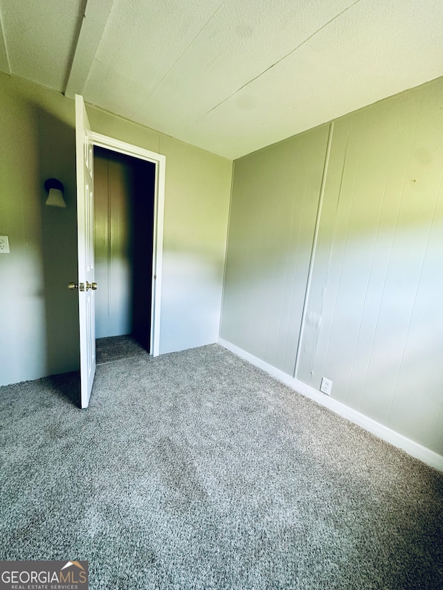 carpeted empty room featuring a textured ceiling