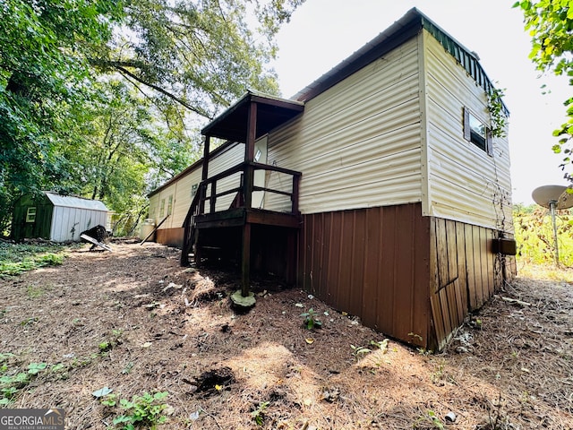 view of property exterior with a storage shed and a deck