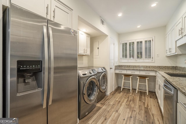 washroom featuring washing machine and dryer, sink, and light hardwood / wood-style floors