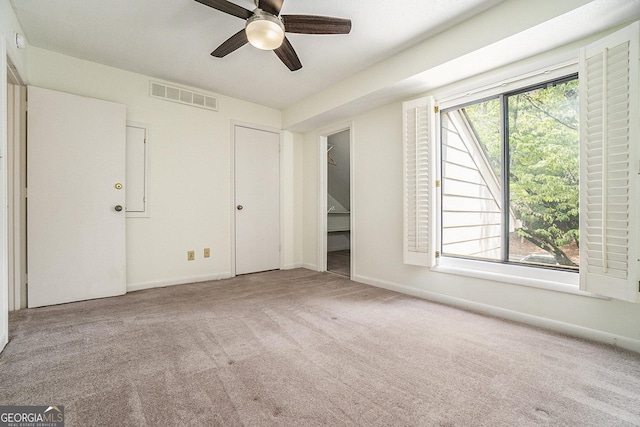 unfurnished bedroom featuring ceiling fan, light colored carpet, and multiple windows