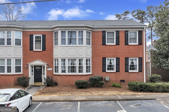 multi unit property featuring uncovered parking, brick siding, crawl space, and a shingled roof